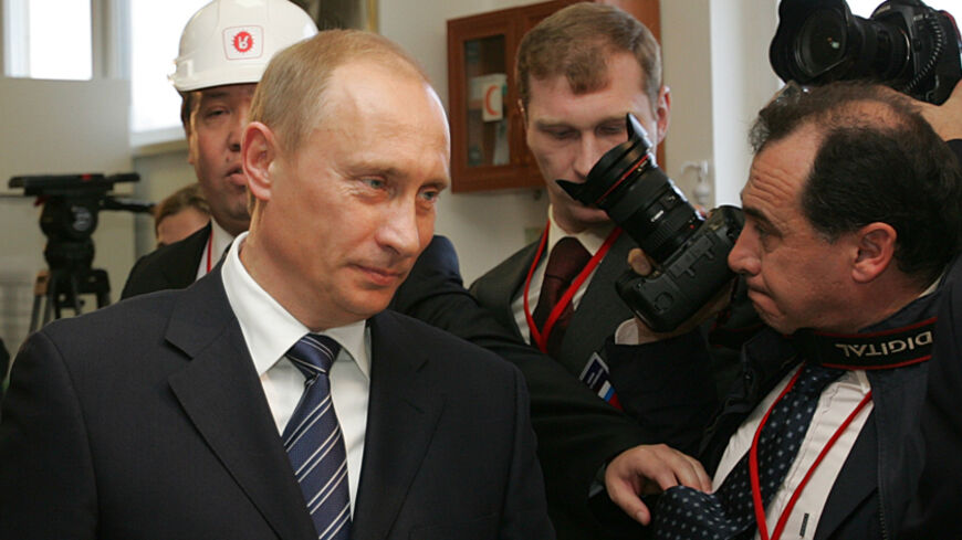 Russian President Vladimir Putin (L) walks past a photographer at the Botas gas pumping station in Durusu near Turkey's Black Sea city of Samsun, November 17, 2005 during the inauguration of a gas pipeline "Blue Stream" carrying Russian gas to Turkey through Black Sea. REUTERS/Mustafa Ozer/Pool - RTR1B7TH