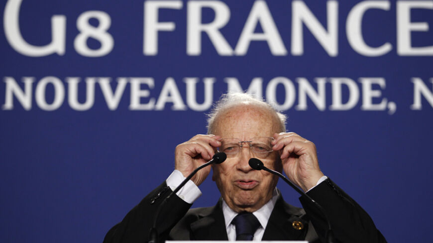 Tunisia's Prime Minister Beji Caid Essebsi adjusts his glasses during a news conference at the G8 summit in Deauville May 27, 2011. REUTERS/Andrew Winning (FRANCE - Tags: POLITICS BUSINESS) - RTR2MYO6