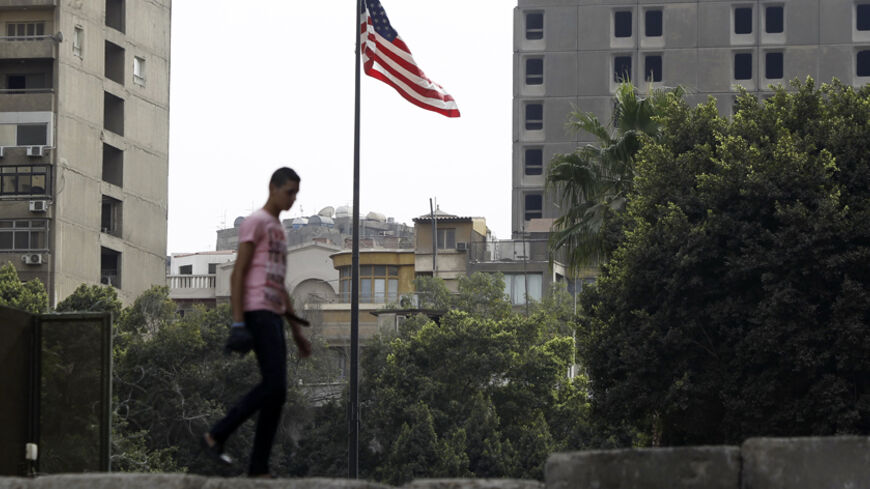An anti-Mursi protester walks on a wall, that was built by police early on Thursday in order to prevent clashes between protesters and police along a road which leads to the U.S. embassy, near Tahrir Square in Cairo November 29, 2012. The body writing Egypt's new constitution began a session to vote on a final draft on Thursday, a move President Mohamed Mursi's allies in the Muslim Brotherhood hope will help end a crisis prompted by a decree expanding his powers. REUTERS/Amr Abdallah Dalsh  (EGYPT - Tags: P