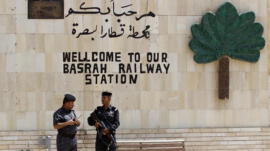Iraqi policemen stand guard at Basra railway station in Basra, southeast of Baghdad, May 13, 2014. China has recently delivered two brand new diesel trains to Iraq. The trains are the first of a fleet of ten trains to be delivered by China in stages within a year in accordance with a deal signed by the Iraqi Republic Railways with China in 2012 as part of an ambitious plan to modernise and upgrade the country's dilapidated railway system.  REUTERS/Essam Al-Sudani (IRAQ - Tags - Tags: POLITICS TRANSPORT) - R