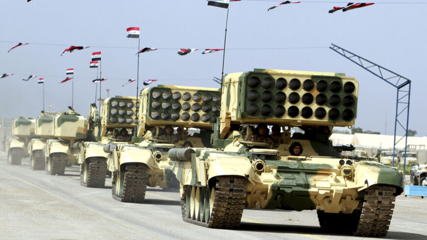 Iraqi Army soldiers ride in tanks with Russian rocket launchers (TOS-1) as part of a parade marking the founding anniversary of the army's artillery section in Baghdad October 1, 2014. REUTERS/Mahmoud Raouf Mahmoud (IRAQ - Tags - Tags: MILITARY ANNIVERSARY) - RTR48K1C