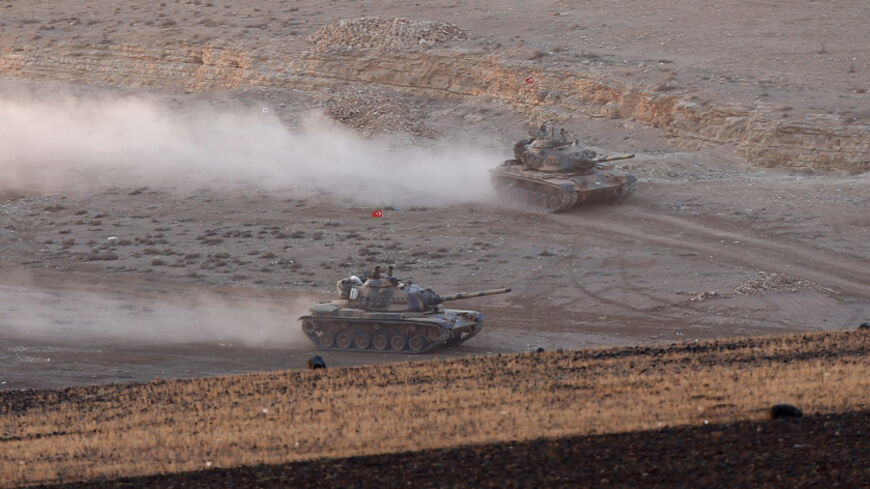 Turkish army tanks manoeuvre near Turkish Kurds (not pictured) watching the Syrian town of Kobani from atop a hill near the Mursitpinar border crossing in the southeastern Turkish town of Suruc in Sanliurfa province November 18, 2014. Turkish Kurds were watching the fighting between Islamic State militants and Kurdish fighters in Kobani. REUTERS/Osman Orsal (TURKEY - Tags: POLITICS MILITARY CONFLICT) - RTR4ELLQ
