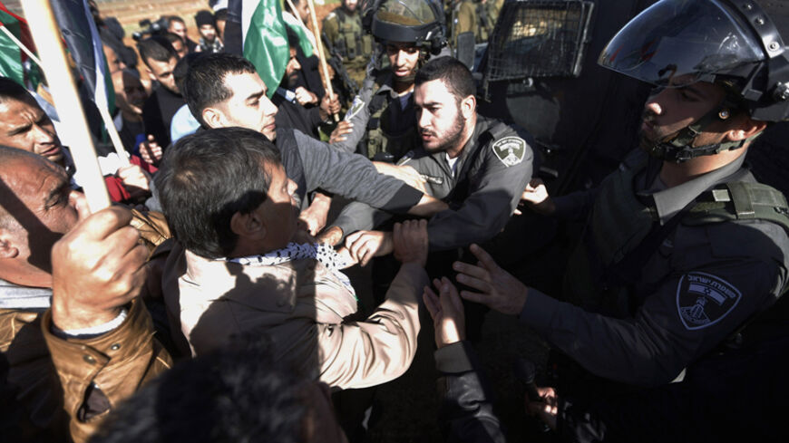Palestinian minister Ziad Abu Ein (C) scuffles with an Israeli border policeman near the West Bank city of Ramallah December 10, 2014. Abu Ein died shortly after being hit by Israeli soldiers during a protest on Wednesday in the occupied West Bank, a Reuters photographer who witnessed the incident and a Palestinian medic said. Abu Ein, a minister without portfolio who was in his early 50s, was rushed by ambulance from the scene, in the village of Turmusiya, but died en route to the nearby Palestinian city o