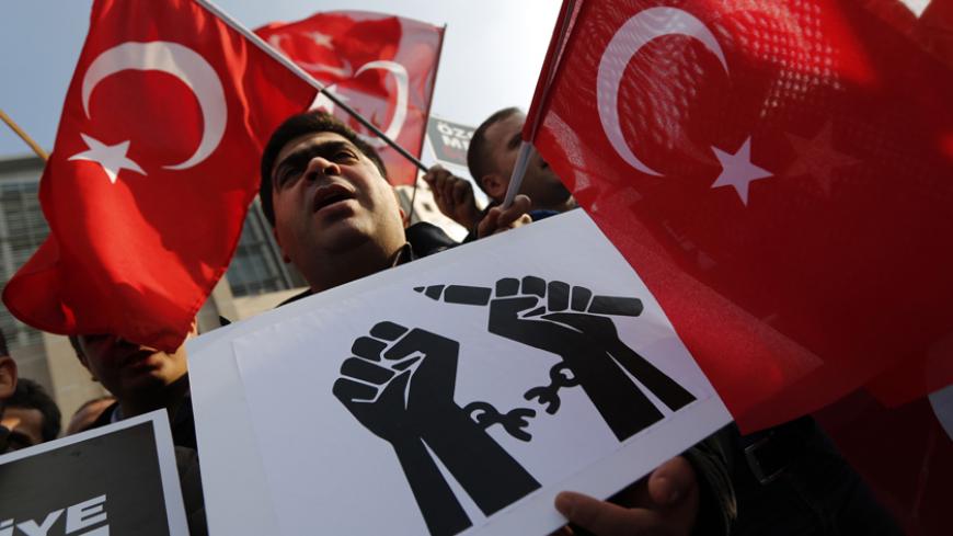 Supporters of the Gulen movement wave Turkish flags as they gather outside the Justice Palace in Istanbul December 19, 2014. A Turkish court kept a media executive and three other people in custody on Friday pending trial on accusations of belonging to a terrorist group, in a case which President Tayyip Erdogan has defended as a response to "dirty operations" by his enemies. Hidayet Karaca heads Samanyolu Television which is close to the president's ally-turned foe Fethullah Gulen, a U.S.-based Muslim cleri