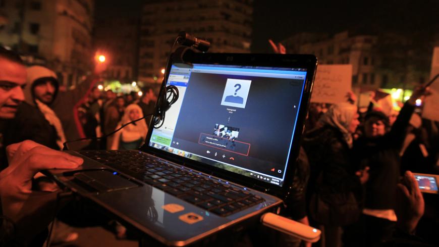 An Egyptian protester streams a demonstration via Skype as people gather in Cairo's Tahrir Square to denounce the military's attacks on women and to call for an immediate end to the violence against protesters on December 20, 2011. AFP PHOTO/MOHAMMED ABED (Photo credit should read MOHAMMED ABED/AFP/Getty Images)