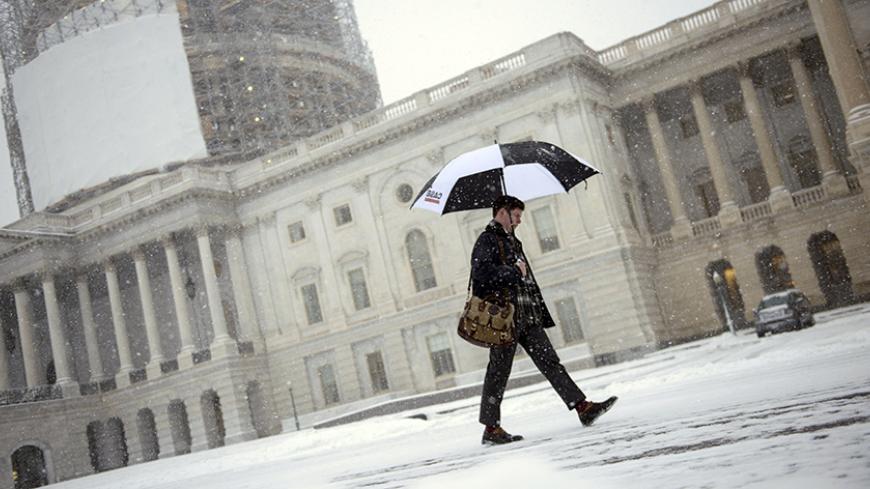 A man walks through snow on Capitol Hill January 6, 2015 in Washington, DC. The 114th Congress convened today with Republicans taking majority control of both the Senate and House of Representatives. The first significant snowfall of the year wrecked havoc on the morning rush hour in the Washington,DC area.  AFP PHOTO/BRENDAN SMIALOWSKI        (Photo credit should read BRENDAN SMIALOWSKI/AFP/Getty Images)