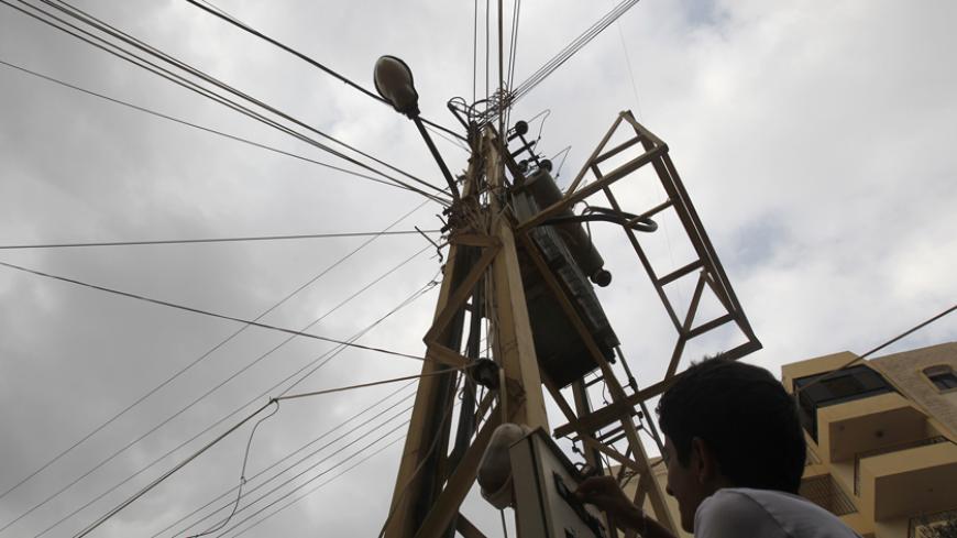 A youth switches on a private generator power after general electricity was cut in Jayeh area, south of Beirut September 22, 2011. Lebanon's parliament passed a $1.2 billion bill on Thursday aimed at boosting electricity output after weeks of political discord over how to allocate the funds transparently.
 REUTERS/Sharif Karim (LEBANON - Tags: ENERGY BUSINESS POLITICS) - RTR2ROJ5