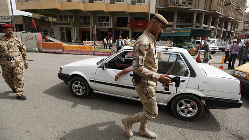 An Iraqi soldier scans a car with a bomb detector a checkpoint at Shurja market in central Baghdad, April 28, 2012. REUTERS/Thaier al-Sudani (IRAQ - Tags : - Tags: CONFLICT MILITARY) - RTR31CIN