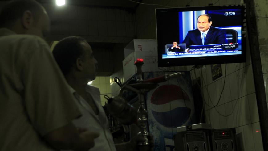 People watch a television interview broadcast on CBC and ONTV with presidential candidate and Egypt's former army chief Abdel Fattah al-Sisi, at cafe in Cairo May 6, 2014. Sisi, who is expected to win a presidential election this month, said in a television interview broadcast on Tuesday that costly energy subsidies could not be lifted quickly. REUTERS/Amr Abdallah Dalsh  (EGYPT - Tags: POLITICS ELECTIONS MILITARY) - RTR3O2A9