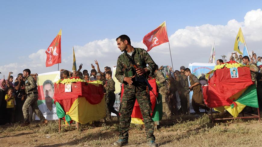 Kurdish People's Protection Units (YPG) members organise a funeral for members who died during recent clashes with forces loyal to Syria's President Bashar Al-Assad in al-Hasakah, activists said May 23, 2014. Picture taken May 23, 2014. REUTERS/Rodi Said (SYRIA - Tags: POLITICS CIVIL UNREST CONFLICT) - RTR3QNP1
