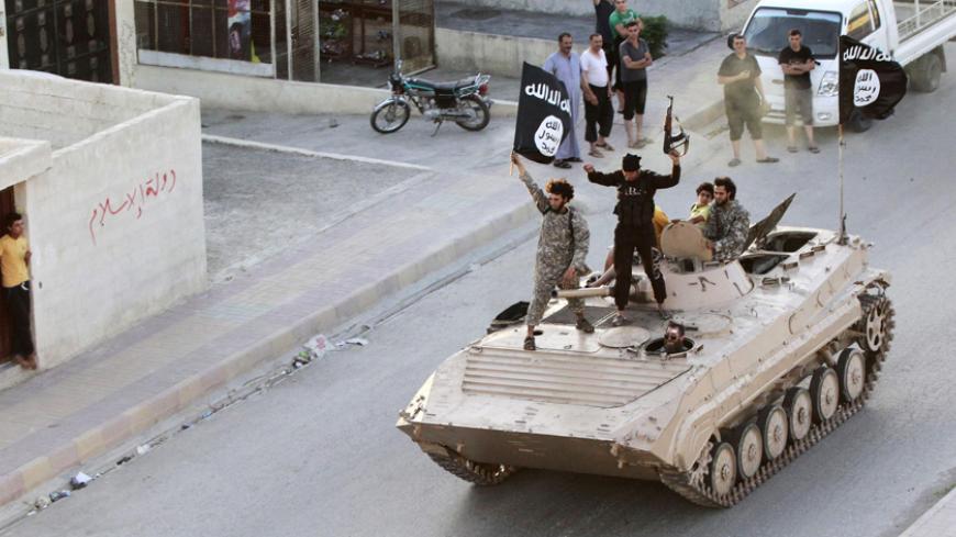 Militant Islamist fighters take part in a military parade along the streets of northern Raqqa province June 30, 2014. Militant Islamist fighters held a parade in Syria's northern Raqqa province to celebrate their declaration of an Islamic "caliphate" after the group captured territory in neighbouring Iraq, a monitoring service said. The Islamic State, an al Qaeda offshoot previously known as Islamic State in Iraq and the Levant (ISIL), posted pictures online on Sunday of people waving black flags from cars 