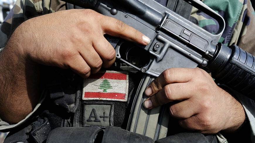 A Lebanese army soldier holds his weapon after being deployed to tighten security, following clashes between Lebanese soldiers and Islamist gunmen in Tripoli, northern Lebanon October 27, 2014. Guns fell silent in the northern Lebanese city of Tripoli on Monday after two days of deadly battles between the army and Islamist gunmen, some of the worst fighting to spill over into Lebanon from Syria's civil war next door. REUTERS/Mohamed Azakir   (LEBANON - Tags: CIVIL UNREST MILITARY) - RTR4BR7A