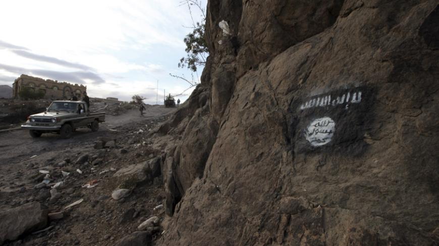 Shi'ite Houthi rebels drive a patrol truck past a Ansar al-Sharia flag painted on the side of a hill, along a road in Almnash, the main stronghold of Ansar al-Sharia, in Rada November 22, 2014. Shi'ite Houthi fighters recently managed to enter the area, which had long been the main stronghold of Ansar al-Sharia, the local wing of Al Qaeda in the Arabian Peninsula (AQAP). Picture taken November 22, 2014. REUTERS/Mohamed al-Sayaghi (YEMEN - Tags: CIVIL UNREST TPX IMAGES OF THE DAY CONFLICT) - RTR4F880