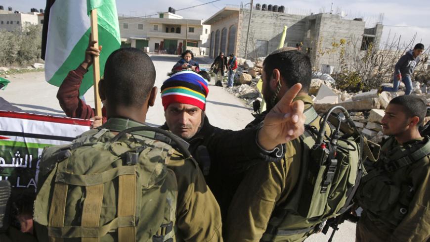 A Palestinian protester argues with Israeli soldiers during a weekly protest against Israeli settlements in the village of Maasara, near the West Bank city of Bethlehem, January 2, 2015.
REUTERS/ Mussa Qawasma (WEST BANK - Tags: CIVIL UNREST MILITARY POLITICS) - RTR4JW3V