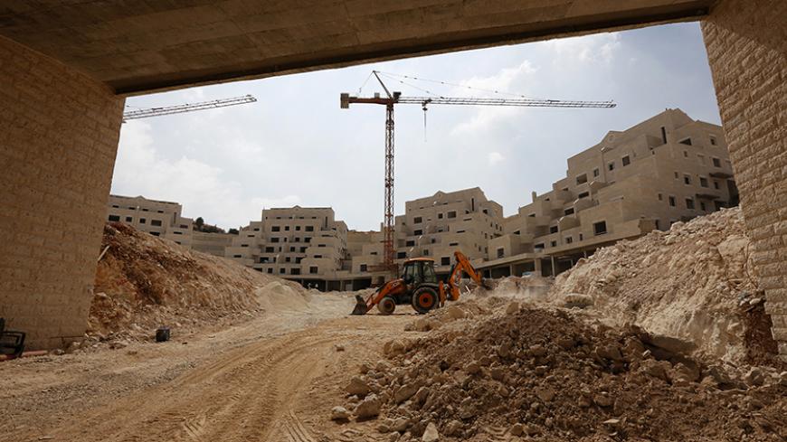 A bulldozer works at a construction site in Pisgat Zeev, an urban settlement in an area Israel annexed to Jerusalem after capturing it in the 1967 Middle East war, August 13, 2013. A 10-minute drive from where negotiators will sit down on Wednesday to resume long-stalled Middle East peace talks, Israeli bulldozers are busy reshaping land that Palestinians want for their future state.
REUTERS/Baz Ratner (JERUSALEM - Tags: POLITICS BUSINESS CONSTRUCTION) - RTX12JQ0