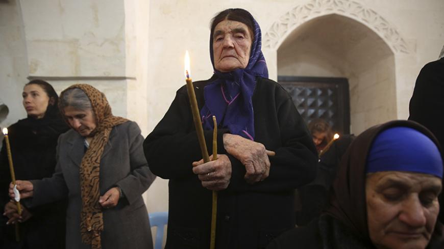 Syriac Christians from Turkey and Syria attend a mass at the Mort Shmuni Syriac Orthodox Church in the town of Midyat, in Mardin province of southeast Turkey February 2, 2014. Despite the empty streets of Midyat, the historical Mort Shmuni Syriac Orthodox Church is overcrowded with a community of three hundred people, mostly children. For longer than two years, not only the native Turkish Christian citizens of Midyat, but also the Syriac families escaping the bloody war in Syria just across the border are j
