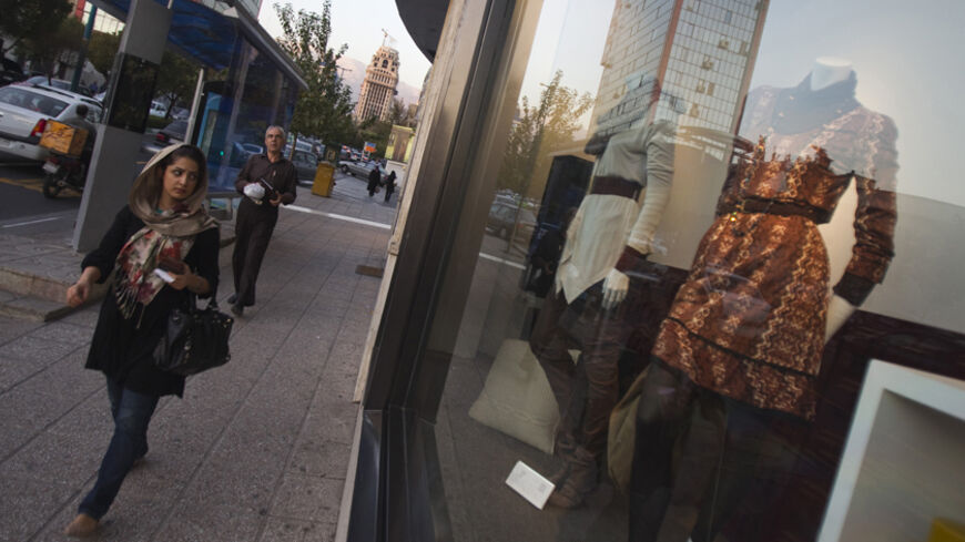 An Iranian woman walks past a shop window of the Mango fashion label in northern Tehran October 24, 2010. While ordinary Iranians struggle to survive international sanctions and deepening economic uncertainty, the gap has widened between the disadvantaged and those who can afford to travel to Paris for a haircut. The extravagant tastes of wealthy Iranians show no signs of abating in spite of tougher sanctions targeting the Islamic state over its disputed nuclear programme. Several new shopping malls packed 