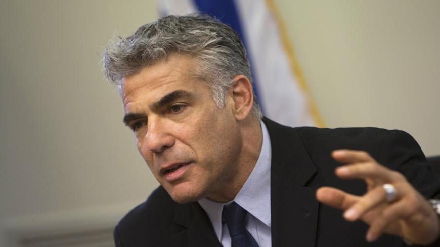 Israel's Finance Minister Yair Lapid gestures as he speaks during a Yesh Atid party meeting at the Knesset, the Israeli parliament, in Jerusalem May 20, 2013. Lapid, whose new centrist party is the second largest in Israel's government, said on Monday thousands of Jewish settlers would have to be removed from occupied land under any peace deal with the Palestinians. REUTERS/Ronen Zvulun (JERUSALEM - Tags: POLITICS) - RTXZTWQ