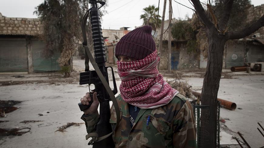 TO GO WITH AFP STORY BY ANTONIO PAMPLIEGA
A masked Syrian Turkmen rebel takes posision in the Hanano district of the northern city of Aleppo on January 28, 2013. Members of Syria's Turkmen minority have joined forces with rebels fighting President Bashar al-Assad's regime in a struggle they say is for democracy and revenge for years of oppression. AFP PHOTO/JM LOPEZ (Photo credit should read JM LOPEZ/AFP/Getty Images)