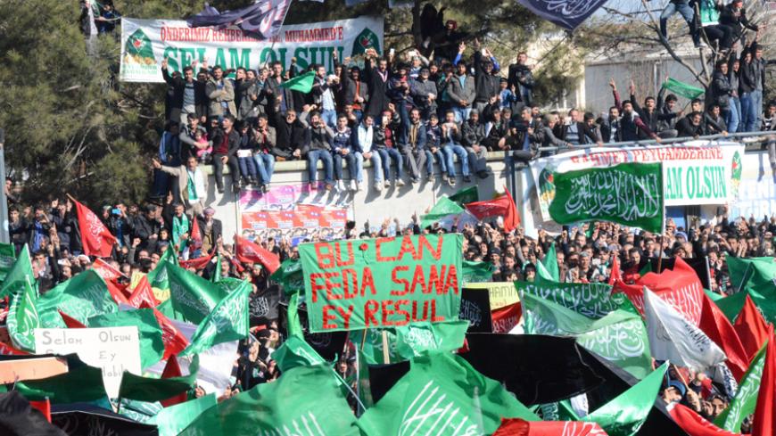 Anti-Charlie Hebdo protesters wave flags and boards and chant slogans as they are gathered in Diyarbakir on January 24, 2015 during a demonstration against the depiction of the Prophet Mohammed by the French satirical weekly and mourning two Islamist gunmen who killed 12 people in an attack on Charlie Hebdo, two weeks ago in Paris. AFP PHOTO/ILYAS AKENGIN (Photo credit should read ILYAS AKENGIN/AFP/Getty Images)