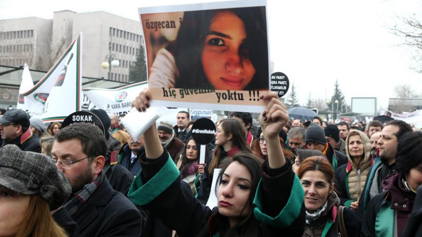 A Member of Turkey's Bar Association holds a poster depicting slain Ozgecan Aslan, in Ankara, on February 16, 2015 during a march to protest against a law that strenghtens the police's power. Anger mounted in Turkey Monday over the murder and attempted rape by a bus driver of the 20-year-old female student whose burned body was discovered on February 13, as a court placed three suspects in pre-trial detention over the brutal killing. AFP PHOTO/ADEM ALTAN (Photo credit should read ADEM ALTAN/AFP/Getty