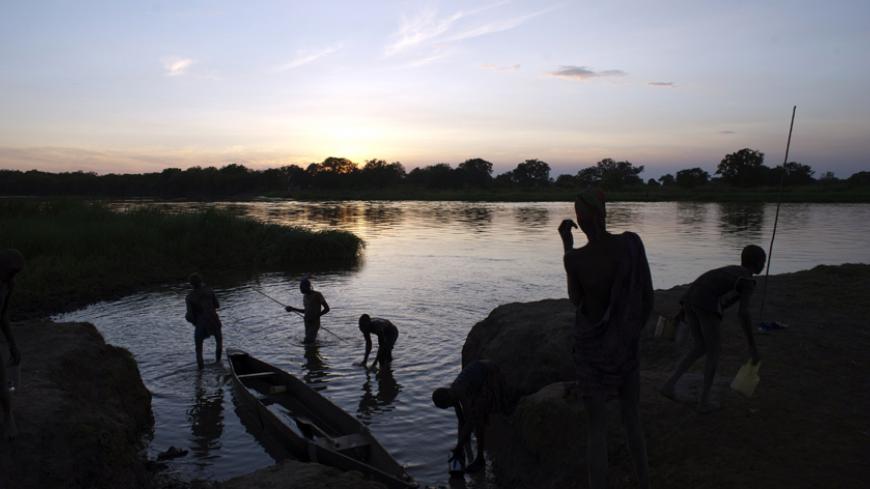 This picture taken on April 13, 2014 shows Mundari youth fishing with a spear along the Nile on April 13, 2014 near Terekeka. Conflict in South Sudan has triggered a serious risk of famine that will kill up to 50,000 children within months if immediate action is not taken, the UN warned on April 11, 2014. AFP PHOTO / ALI NGETHI        (Photo credit should read ALI NGETHI/AFP/Getty Images)