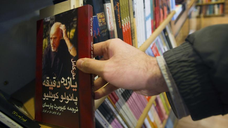 EDITORS' NOTE: Reuters and other foreign media are subject to Iranian restrictions on leaving the office to report, film or take pictures in Tehran.
A customer holds a copy of the translated novel "Eleven Minutes" written by the Brazilian novelist Paulo Coelho at a bookshop in central Tehran January 29, 2011. Iranians are feeling the pinch from radical cuts in state subsidies, a plan President Mahmoud Ahmadinejad has called "the biggest economic plan in the past 50 years". The cuts in long-standing subsidi