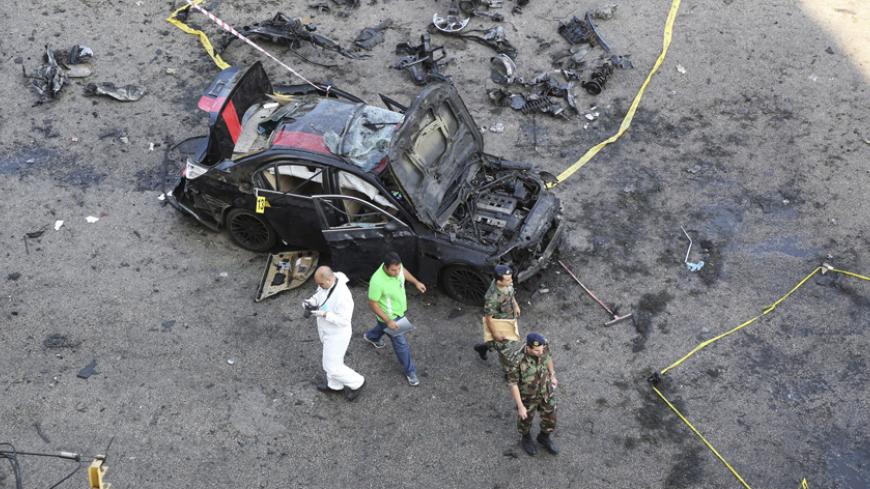 A Forensic inspector and Lebanese army soldiers work at a site of explosion that occured on Monday night in the southern suburbs of the Lebanese capital Beirut June 24, 2014. A suicide bomber blew up his car in Beirut on Monday night near an army checkpoint, killing a security officer and wounding several people watching the soccer World Cup in a nearby cafe. Security forces have been on high alert since a suicide bomber killed one person and wounded 37 near the Syrian border on Friday in an attack that nar