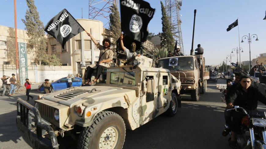 Militant Islamist fighters take part in a military parade along the streets of Syria's northern Raqqa province June 30, 2014. The fighters held the parade to celebrate their declaration of an Islamic "caliphate" after the group captured territory in neighbouring Iraq, a monitoring service said. The Islamic State, an al Qaeda offshoot previously known as Islamic State in Iraq and the Levant (ISIL), posted pictures online on Sunday of people waving black flags from cars and holding guns in the air, the SITE m