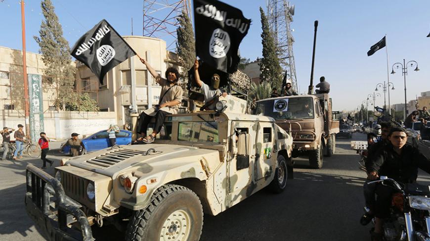 Militant Islamist fighters take part in a military parade along the streets of Syria's northern Raqqa province June 30, 2014. The fighters held the parade to celebrate their declaration of an Islamic "caliphate" after the group captured territory in neighbouring Iraq, a monitoring service said. The Islamic State, an al Qaeda offshoot previously known as Islamic State in Iraq and the Levant (ISIL), posted pictures online on Sunday of people waving black flags from cars and holding guns in the air, the SITE m