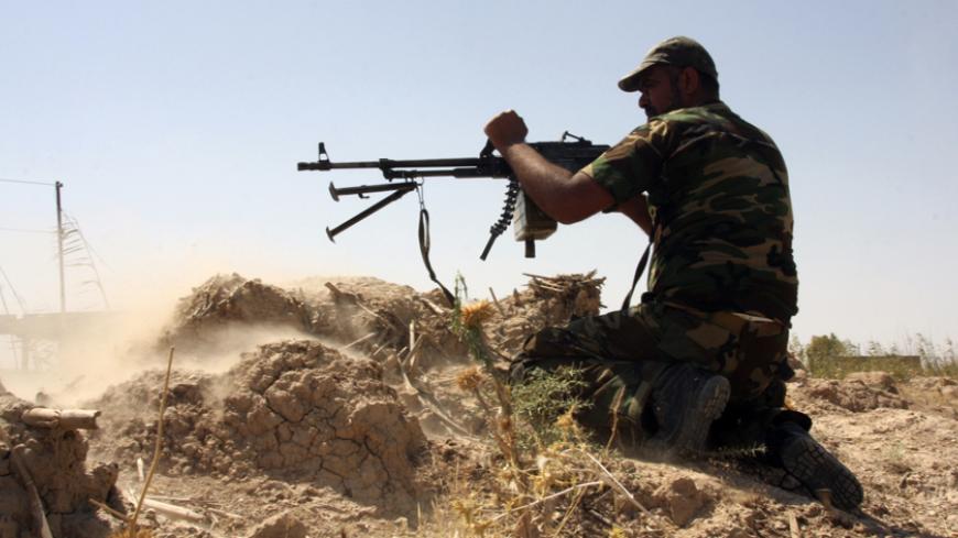 An armed Shi'ite volunteer from the Mehdi Army, loyal to radical cleric Muqtada al-Sadr, clashes with Islamic State (IS) militants outside the city of Tikrit September 8, 2014. Picture taken September 8, 2014.REUTERS/Stringer (IRAQ - Tags: CIVIL UNREST POLITICS CONFLICT) - RTR45WNV