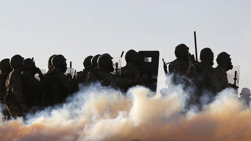 Turkish soldiers use tear gas to disperse Turkish Kurdish protesters near the Mursitpinar border crossing on the Turkish-Syrian border, in the Turkish town of Suruc in southeastern Sanliurfa province October 4, 2014. Turkish security forces broke up a pro-Kurdish demonstration in solidarity with Syrian Kurds, on the Turkish-Syrian border. REUTERS/Murad Sezer (TURKEY - Tags: MILITARY POLITICS CIVIL UNREST CONFLICT TPX IMAGES OF THE DAY) - RTR48X5W
