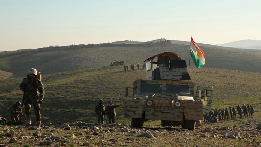Kurdish Peshmerga fighters walk with their weapons as they take control of the area, on the outskirts of Mosul February 6, 2015.  REUTERS/Ari Jalal   (IRAQ - Tags - Tags: CIVIL UNREST CONFLICT MILITARY POLITICS) - RTR4OJRR
