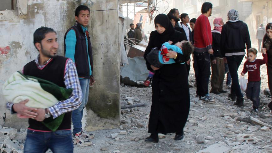 Civilians carry their children as they flee, after what activists said were two barrels bombs dropped by forces loyal to Syria's President Bashar al-Assad, in the northwestern Homs district of Al Waer, February 7, 2015. REUTERS/Stringer (SYRIA - Tags: POLITICS CIVIL UNREST CONFLICT) - RTR4OLPY