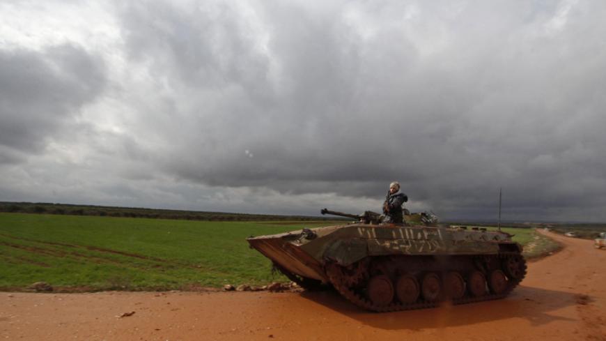 Rebel fighters of al-Jabha al-Shamiya (the Shamiya Front) sit in an armoured vehicle along a main road between Raitan and Bashkuwi villages, north of Aleppo February 19, 2015. Battles in and around the Syrian city of Aleppo have killed at least 70 pro-government fighters and more than 80 insurgents after the army launched an offensive there, a monitoring group said on Wednesday. REUTERS/Rami Zayat   (SYRIA - Tags: POLITICS CIVIL UNREST CONFLICT MILITARY) - RTR4Q8LA