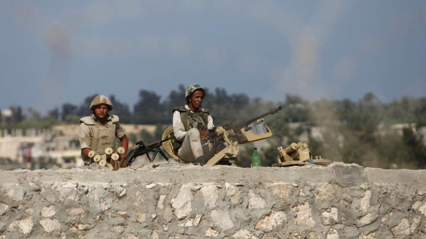 Egyptian soldiers keep guard on the border between Egypt and southern Gaza Strip July 8, 2013. Armed men launched a series of attacks on Sunday on security checkpoints in the North Sinai towns of Sheikh Zuweid and El Arish close to Egypt's border with Israel and the Gaza Strip, and one soldier was killed. The Rafah border crossing between Egypt and Gaza Strip remained closed since Friday.
REUTERS/Ibraheem Abu Mustafa (GAZA - Tags: POLITICS CIVIL UNREST MILITARY) - RTX11GFK