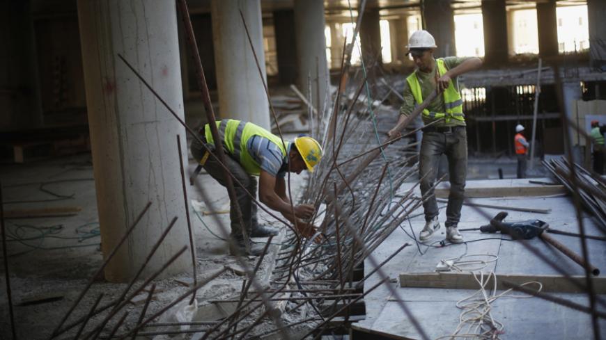 Palestinian labourers work on a construction site in the new Palestinian town dubbed Rawabi or "The Hills", near the West Bank city of Ramallah October 27, 2013. The crackdown on the Gaza Strip as Egypt demolishes the smuggling tunnels along its sandy border, and stagnation in the West Bank mean the Palestinian economy might shrink this year after average annual growth of about nine percent in 2008-2011. To match Analysis PALESTINIANS-ECONOMY/ REUTERS/Mohamad Torokman (WEST BANK - Tags: POLITICS BUSINESS