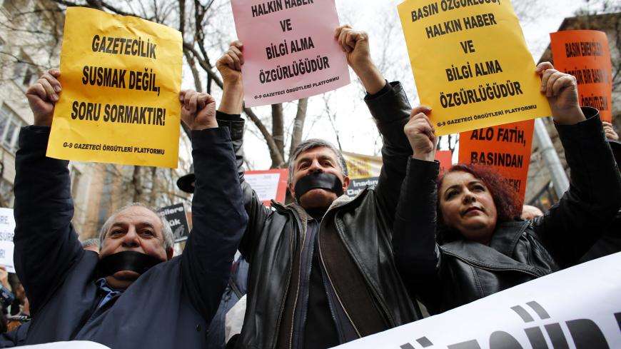 Journalists demanding freedom for the media take part in a protest against Turkey's ruling AK Party (AKP) in Ankara February 15, 2014. The signs read: "Journalism is asking questions, not keeping silent" (L) and "Press freedom also means people's freedom to access information" (C and R). REUTERS/Umit Bektas (TURKEY - Tags: POLITICS CIVIL UNREST MEDIA) - RTX18VGG