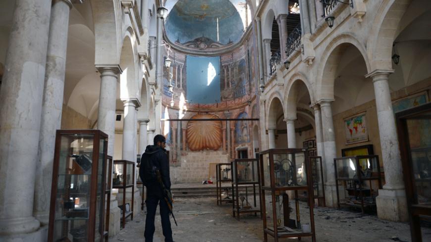 A Syrian rebel looks at damaged display cases inside a former church turned into a film museum which was shelleld by government forces in Aleppo's old city on January 17, 2013. Rebels trying to break a months-long deadlock in their battle for Syria's second city Aleppo say they are cutting supply routes ahead of simultaneous assaults on regime bases.  AFP PHOTO/AAMIR QURESHI        (Photo credit should read AAMIR QURESHI/AFP/Getty Images)