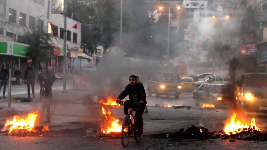 Palestinians burn tires at the entrance to the Balata refugee camp, close to the northern West Bank city of Nablus, on January 21, 2013, as they call for the release of several gunmen arrested two days ago by Palestinian security. AFP PHOTO/JAAFAR ASHTIYEH        (Photo credit should read JAAFAR ASHTIYEH/AFP/Getty Images)