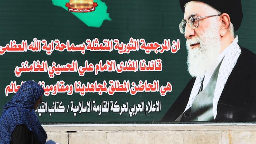 An Iraqi woman walks past a giant poster showing Iran's supreme leader Ayatollah Ali Khamenei in Tahrir Square in central Baghdad on February 05, 2015. Iraqi Prime Minister Haider al-Abadi has ordered an end to a years-old nightly curfew in the Iraqi capital in a bid to ease restrictions on daily life despite persistent violence, officials said. The army and police checkpoints across Baghdad cause massive traffic jams that are a major source of irritation for Iraqis and often follow lax security procedures 