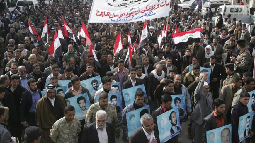 Protesters hold up Iraqi flags and pictures of their relatives who were killed during the Saddam era in a rally against the return of Saddam Hussein's Baath party, in Kerbala, 80 km (50 miles) southwest of Baghdad February 10, 2010.    REUTERS/Mushtaq Muhammed (IRAQ - Tags: CIVIL UNREST POLITICS) - RTR2A18M