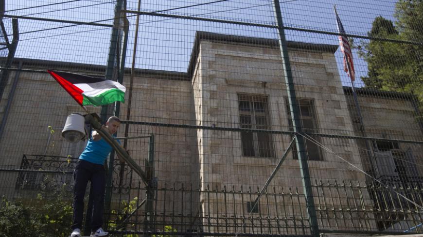 A man places a Palestinian flag on a fence surrounding the U.S. consulate during a rally in support of Palestinian President Mahmoud Abbas' bid for statehood recognition in the United Nations, in Arab East Jerusalem September 21, 2011. Abbas plans on Friday to submit an application for full U.N. membership for the state of Palestine based in the West Bank, East Jerusalem and the coastal Gaza Strip -- lands occupied by Israel in 1967. REUTERS/Ronen Zvulun (JERUSALEM - Tags: POLITICS) - RTR2RM9T