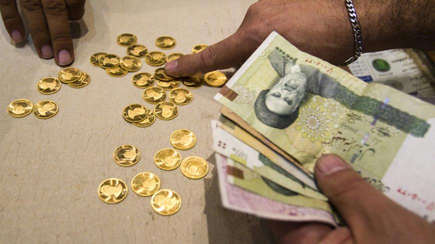 EDITORS' NOTE: Reuters and other foreign media are subject to Iranian restrictions on leaving the office to report, film or take pictures in Tehran.

A customer buys Iranian gold coins at a currency exchange office in Tehran's business district October 24, 2011. Iranian media reported last week that monetary authorities had reversed a six-month-old decision to cut interest on bank deposits, aiming to mop up excess cash in the economy and halt a dangerous rise of inflation. The news made sense to economists,