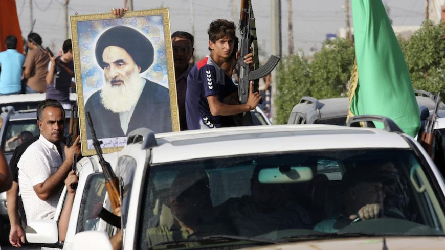 Volunteers, who have joined the Iraqi Army to fight against predominantly Sunni militants, carry weapons and a portrait of Grand Ayatollah Ali al-Sistani during a parade in the streets in Baghdad's Sadr city June 14, 2014. An offensive by insurgents that threatens to dismember Iraq seemed to slow on Saturday after days of lightning advances as government forces regained some territory in counter-attacks, easing pressure on the Shi'ite-led government in Baghdad.  REUTERS/Wissm al-Okili   (IRAQ - Tags: CIVIL 