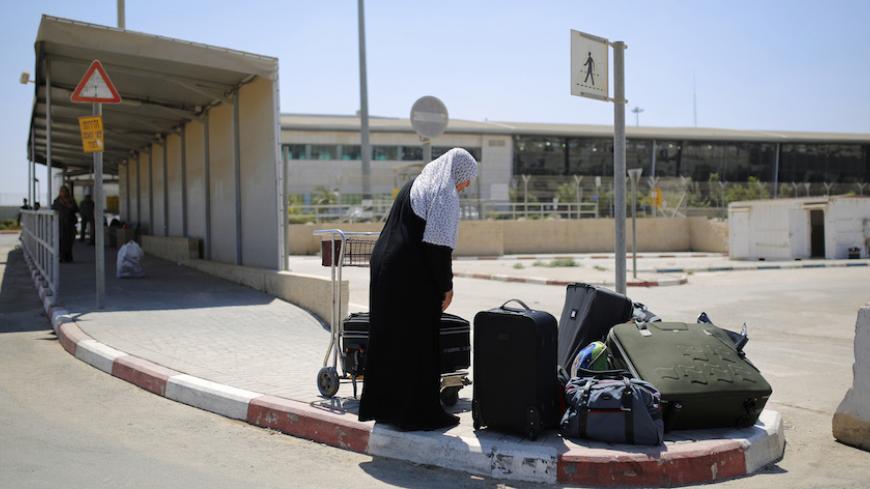 A Palestinian woman loads her suitcases onto a luggage cart before crossing into Gaza through Israel's Erez crossing August 6, 2014. A Gaza truce was holding on Wednesday as Egyptian mediators pursued talks with Israeli and Palestinian representatives on an enduring end to a war that has devastated the Hamas Islamist- dominated enclave. Israel withdrew ground forces from the Gaza Strip on Tuesday morning and started a 72-hour Egyptian-brokered ceasefire with Hamas as a first step towards a long-term deal.