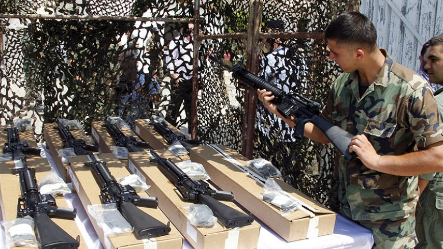 A Lebanese Army soldier inspects a weapon donated by the U.S. government to the Lebanese army during a ceremony at Beirut international airport August 29, 2014. REUTERS/Mohamed Azakir  (LEBANON - Tags: POLITICS MILITARY) - RTR44884