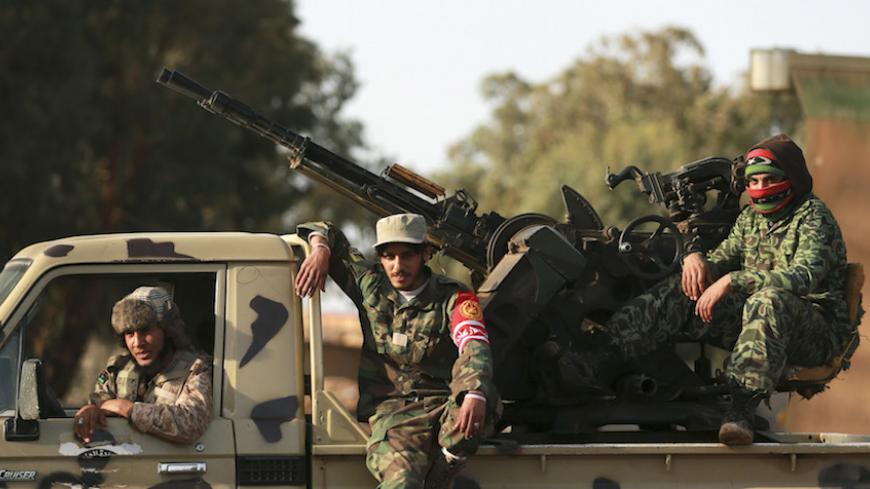 Members of Libyan pro-government forces, which is backed by the locals, look on in an army camp, in Benghazi February 1, 2015. Violent clashes between Libyan pro-government forces and the Shura Council of Libyan Revolutionaries, an alliance of former anti-Gaddafi rebels, who have joined forces with the Islamist group Ansar al-Sharia, have occurred in the areas surrounding the camp. Picture taken February 1, 2015. REUTERS/Esam Omran Al-Fetori (LIBYA  - Tags: CIVIL UNREST POLITICS MILITARY) - RTR4NUE6