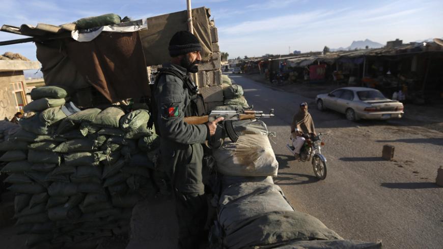 A policeman keeps watch at a checkpoint on the outskirts of Farah province February 4, 2015. Farah offers a prime example of Afghanistan's nexus between Islamist militancy, crime, opium and Kabul's feeble grip on power. Residents say problems escalated after foreign troops withdrew in early 2013 and locals in Farah's most lawless areas say the breakdown in order is complete. Farah has doubled its poppy harvest in five years, is Afghanistan's third largest opium producing region and occupies a key position i