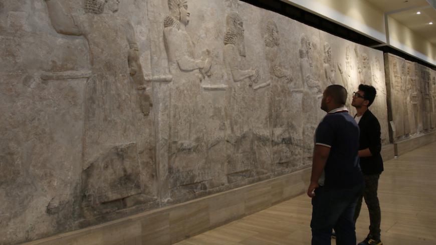 Visitors look at Assyrian mural sculptures from Khorsabad, at the Iraqi National Museum in Baghdad March 8, 2015. Islamic State militants have desecrated another ancient Iraqi capital, the government said on March 11, 2015, razing parts of the 2,700-year-old city of Khorsabad famed for its colossal statues of human-headed winged bulls. Picture taken March 8, 2015. REUTERS/Khalid al-Mousily (IRAQ - Tags: SOCIETY CIVIL UNREST) - RTR4SZAO